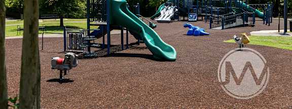 A playground with a green slide and a yellow slide.