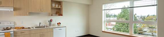 A kitchen with wooden floors and white appliances.