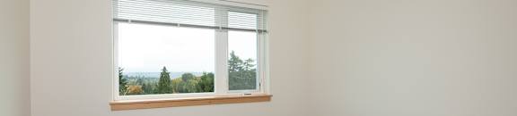 A room with a window and wooden flooring.
