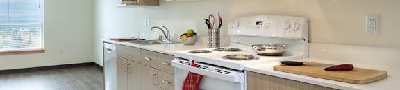 A kitchen with a white oven and wooden cabinets.