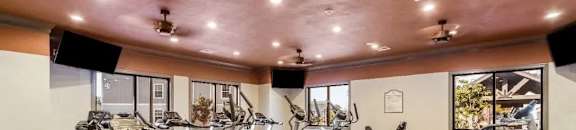A well-equipped gym with a variety of cardio machines at Reserve at Gulf Hills Apartment Homes in Ocean Springs, MS