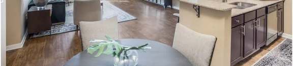 A modern kitchen with a dining table and chairs at Reserve at Gulf Hills Apartment Homes in Ocean Springs, 39564
