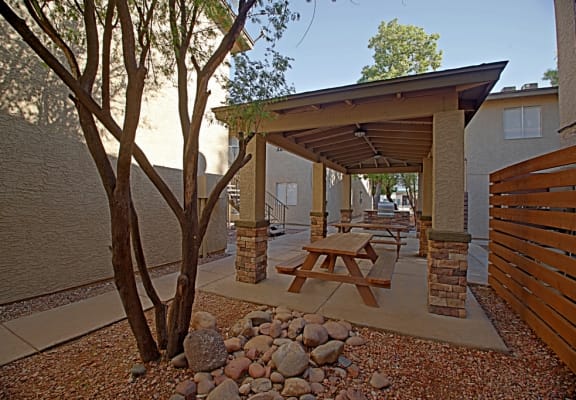 a patio with a picnic table and a tree