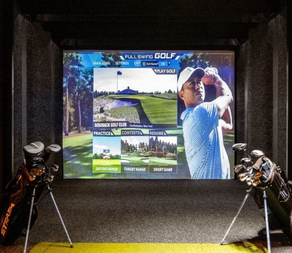 a display of golf equipment in front of a tv screen