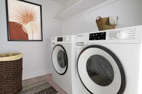 a washer and dryer in a laundry room with a painting on the wall