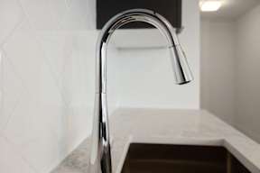 A modern kitchen sink with a chrome faucet.