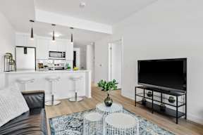 A modern living room with a black leather couch and a white coffee table.
