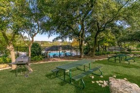 Outdoor grill and picnic area with pool view