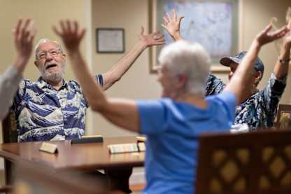 A group of elderly people are playing a card game together.