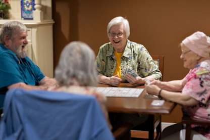 Four elderly people playing a board game.
