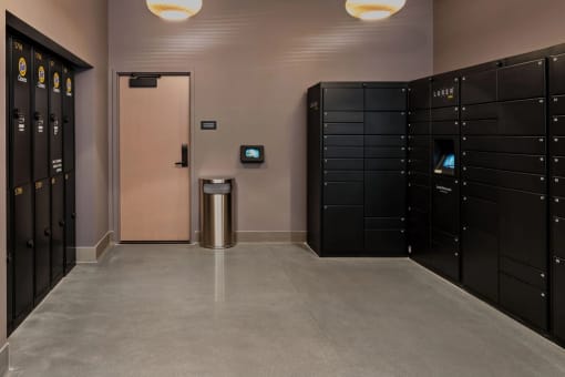 a row of black lockers in a room with a pink door