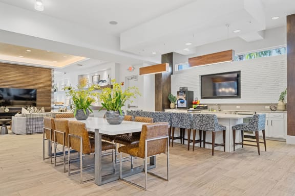 a dining area with a table and chairs and a kitchen with a television at Inspira, Florida, 34113