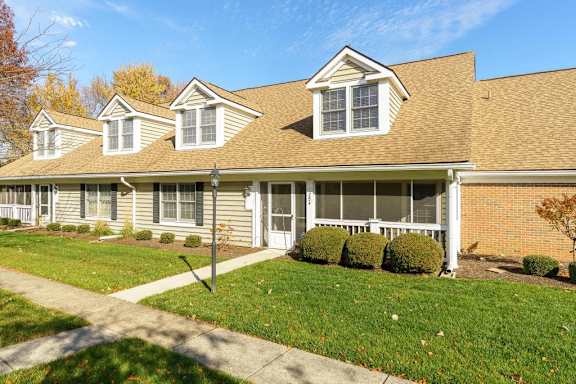 a house with a lawn and a sidewalk in front of it
