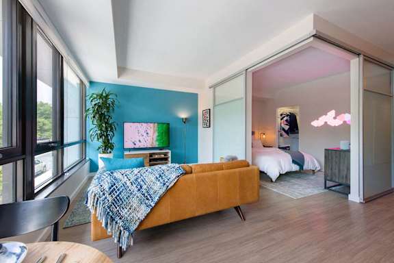 A bedroom with a bed, a couch, and a chair at Artline Apartments, Washington, DC, 20024