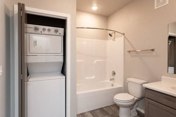 A white toilet is in a bathroom next to a bathtub.