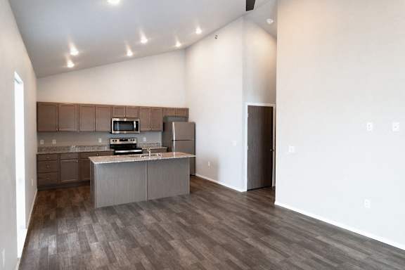 A kitchen with a refrigerator, microwave, and oven.