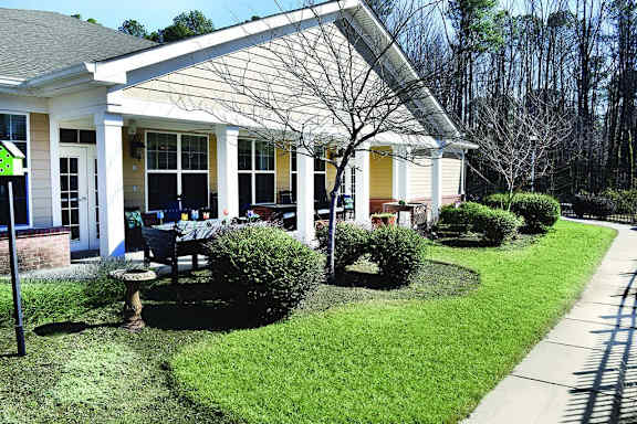 a porch with a table and chairs in front of a house