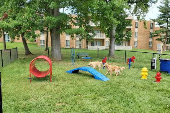A playground with a red slide and a blue bench.
