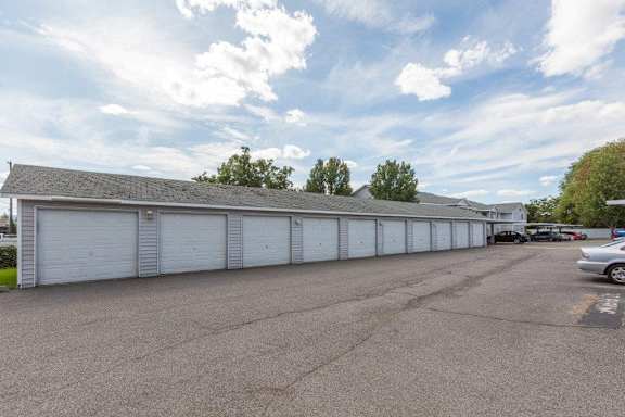 A parking lot with garages and cars.
