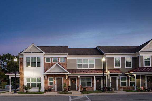 a row of town homes on a street at dusk