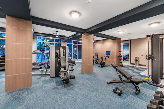 A gym with a variety of equipment including weights and cardio machines. at Morea Apartments, Pompano Beach, Florida