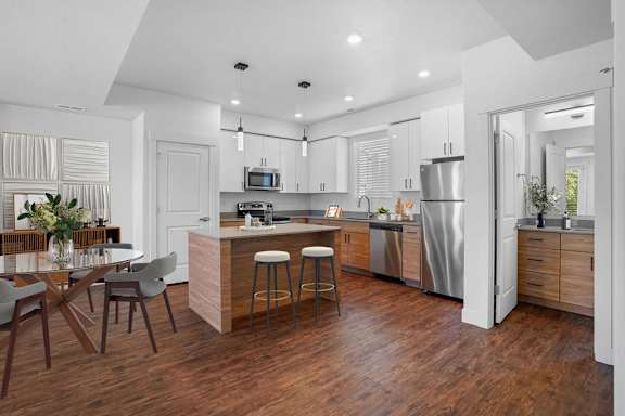 A modern kitchen with a wooden floor and stainless steel appliances.