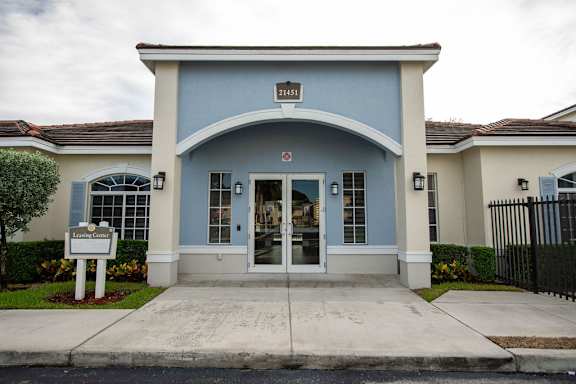 The front of a building with a blue facade and a sign that reads "Leone Center."