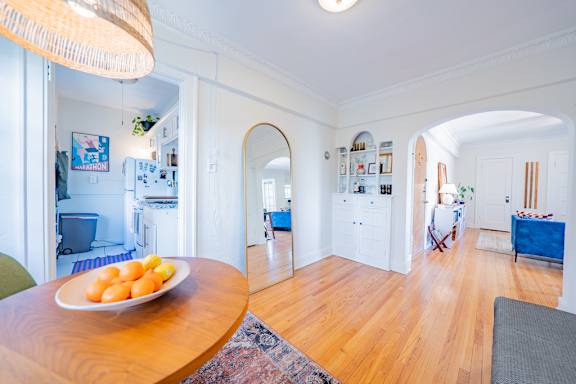 A dining room with a plate of oranges on the table.
