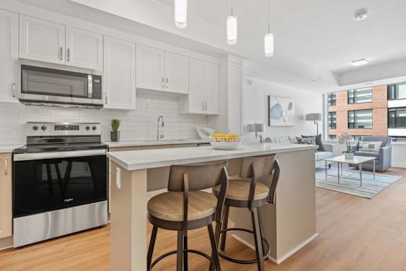 A modern kitchen with white cabinets and a large island.