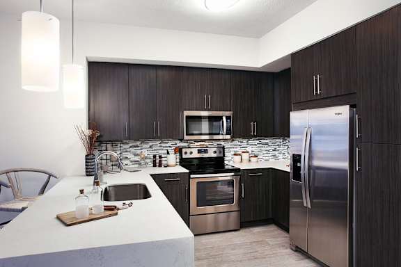  Waterfall edge quartz kitchen countertops and stainless steel appliances