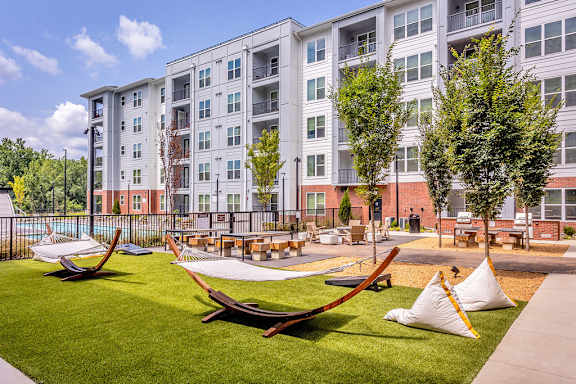 Outdoor entertaining area with hammocks, cornhole, firepit and grills