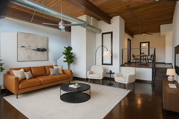 A living room with a brown couch and a white rug.
