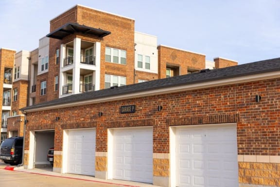 a brick building with three white garage doors