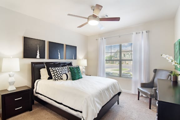 a bedroom with a large bed and a ceiling fan  at Faulkner Flats Apartment Homes, Mississippi, 38655