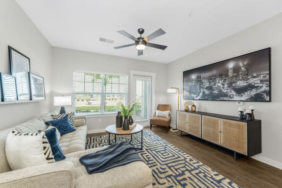 a living room with a ceiling fan and a large window