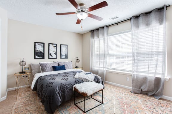 a bedroom with a bed and a ceiling fan at Indigo Apartments Gainesville, Gainesville, GA