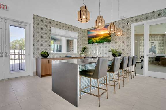 A kitchen with a large island and chairs.