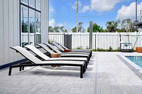A poolside area with sun loungers and a pool.