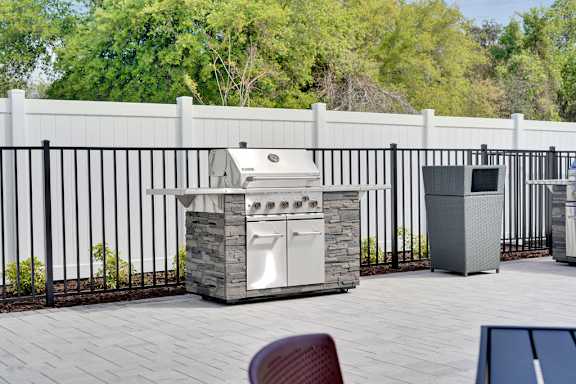A white outdoor kitchen with a grill and sink.