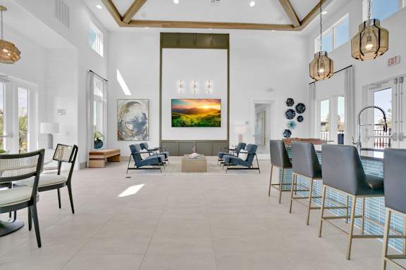 A large room with a painting of a sunset and several chairs.