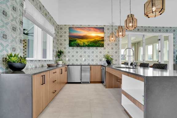 A kitchen with a large painting of a sunset on the wall.