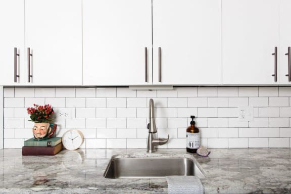 a kitchen counter with a sink and white cabinets