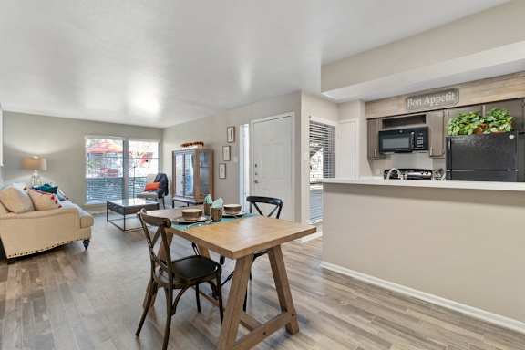 Open layout with dining table and kitchen passthrough at The Colony Apartments, Universal City, TX 78148