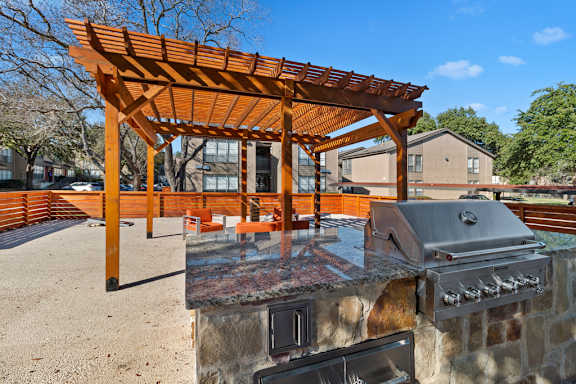 Outdoor grilling area with pergola and built in barbecue at The Colony Apartments, Universal City, TX