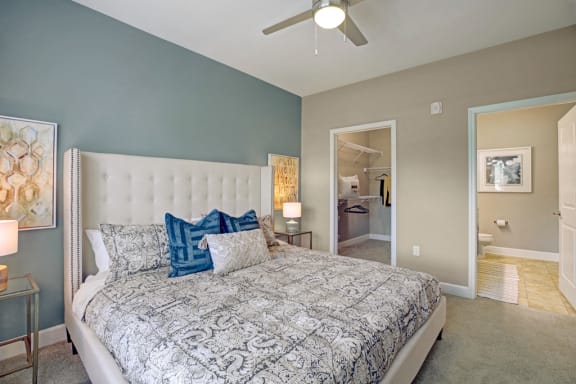 Big bedroom with big bed two tables on each end with carpet going through bedroom and walk in closet at Ascent at Mallard Creek Charlotte, NC