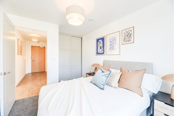 A bedroom with a bed, desk, and chair.