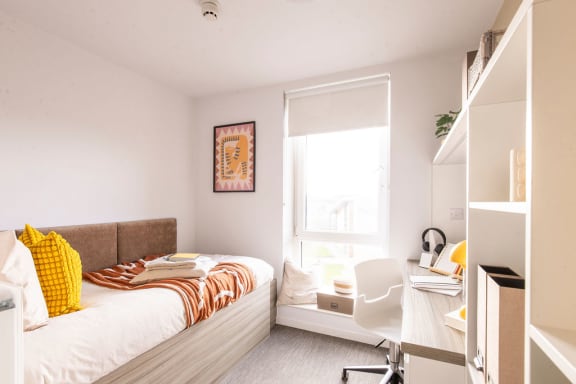 a small bedroom with a bed and a table with two chairs
