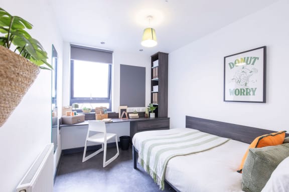a bedroom with a bed and a desk and a window