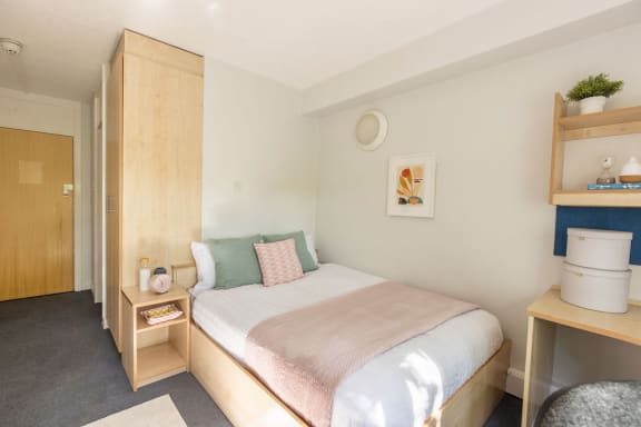 a bedroom with wooden furniture and a white bedspread