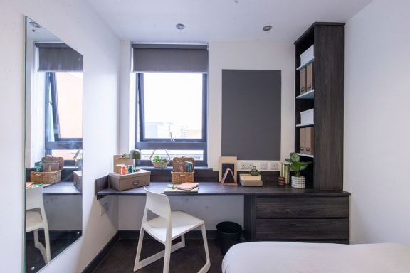 a bedroom with a desk and a window